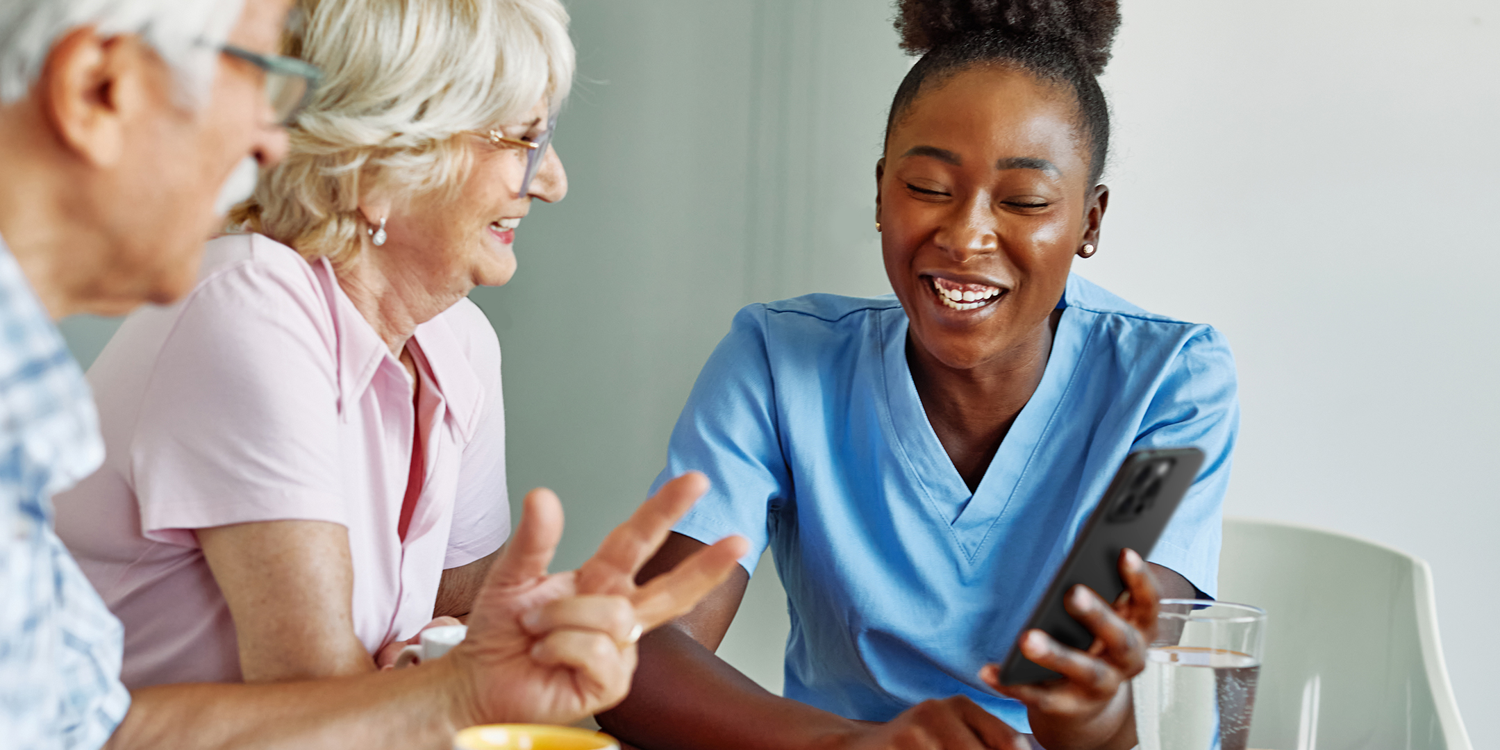 A healthcare professional reviewing information of a phone with two individuals